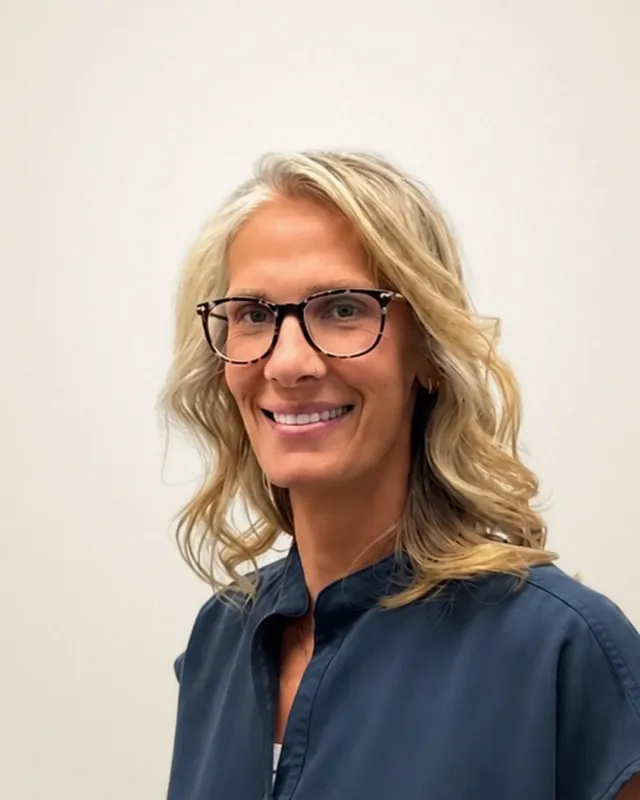 Jessica De Oca, FNP-C, family nurse practitioner at Health First Urgent Care, in navy scrubs and tortoiseshell glasses
