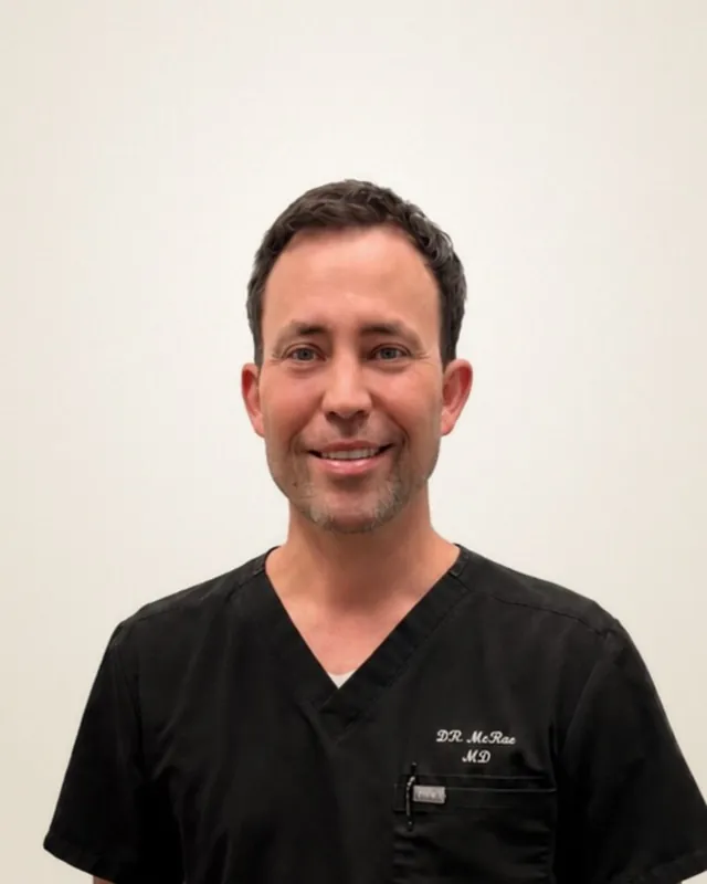 Dr. Brenden McRae, MD, founder and physician at Health First Urgent Care, in embroidered black scrubs